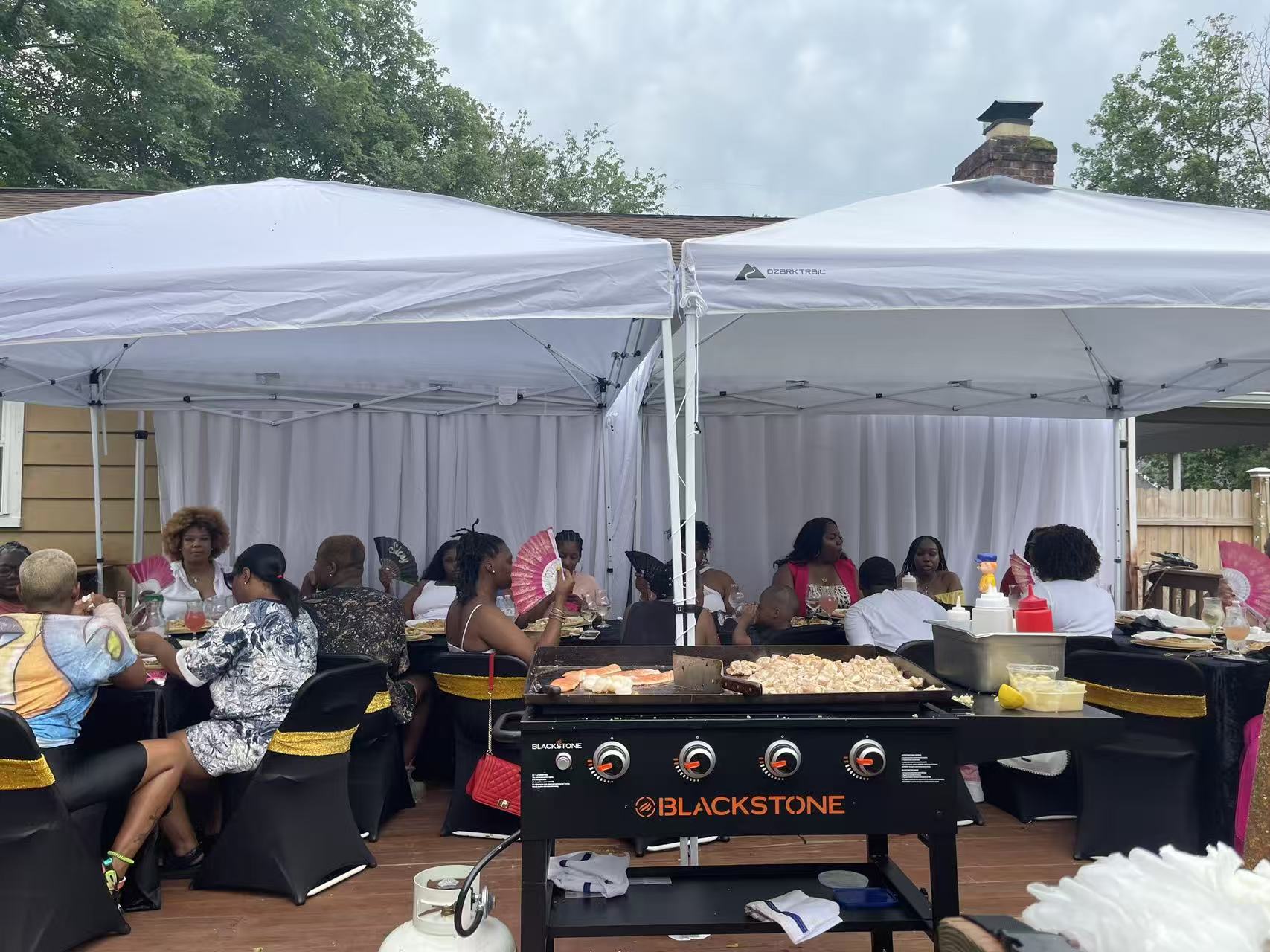 Outdoor hibachi tent party with guests