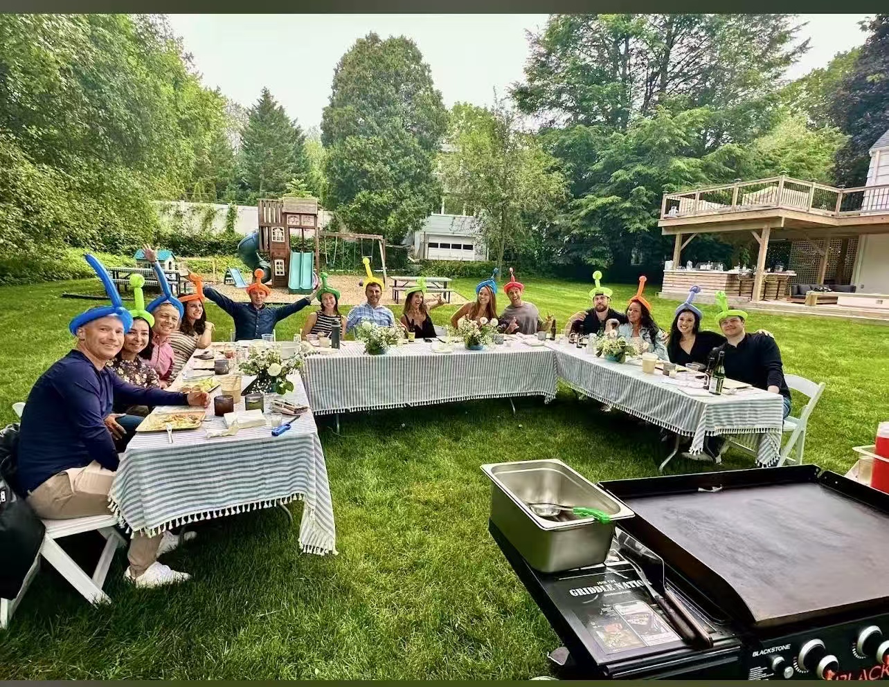 Fun backyard hibachi party with guests wearing party hats