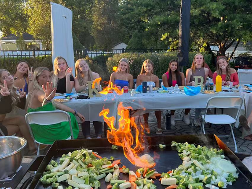 Teen birthday hibachi party with guests around grill